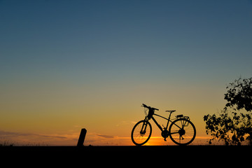 Fototapeta na wymiar Silhouette of bicycles on the road with the sunset background.