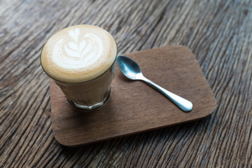 cafe latte on a wooden table with heart shape latte art