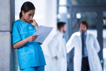 Thoughtful nurse examining a medical report