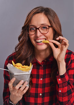 Mujer nerd comiendo patatas fritas.