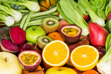 Closeup orange slice with various fresh fruits and vegetables for eating healthy