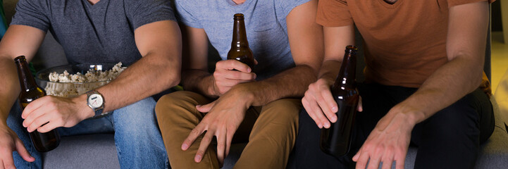 Men sitting on a couch with beer