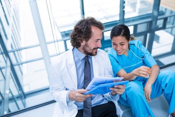 Happy doctor and nurse discussing over a report