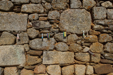 stone wall with metal string hanger and clothes pegs