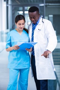 Doctor and nurse discussing over a report