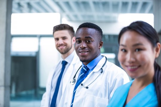 Confident doctor standing with colleagues