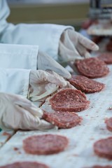 Butchers processing hamburger patty