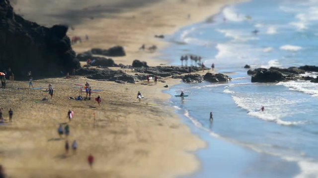 A tilt shift time lapse with surfers walk. No recognizable people, trademarks or logos!
