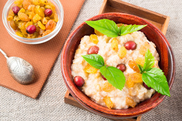 Oatmeal in a wooden bowl on the table at vintage style