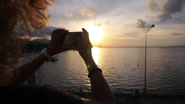 Woman Hands Taking Picture with Mobile Phone at Sunset