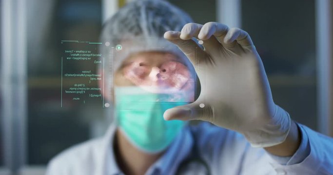 A physician, surgeon, examines a technological digital holographic plate represented the patient's body, the heart lungs, muscles, bones. Concept: Futuristic medicine, the human body, and the future.