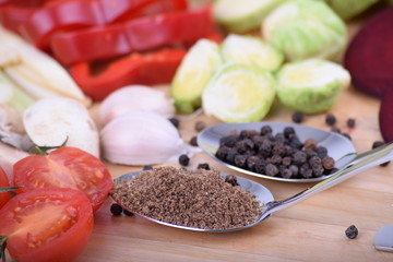 Vegetables and grains on spoons served on a wooden board close up