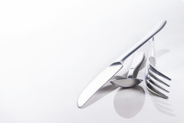 Messer, Gabel und Teelöffel auf spiegelndem Untergrund, Hintergrund