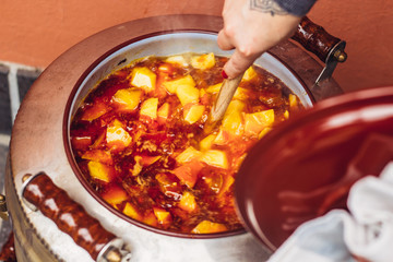 Cooking potatoes with chorizo in a huge pot.