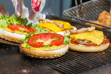 hamburgers being grilled with flames