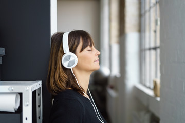 frau hört musik mit geschlossenen augen