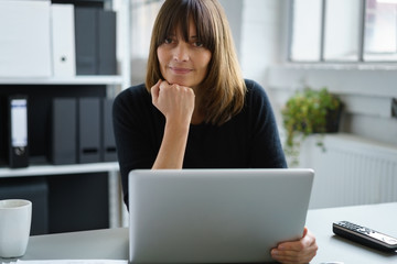 frau arbeitet mit laptop am schreibtisch