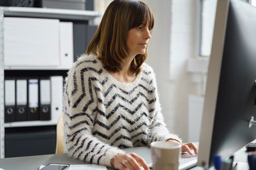 frau arbeitet am computer im büro