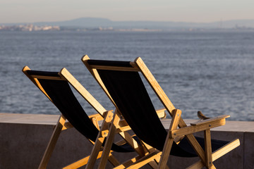 chaser longue on waterfront of a river in evening