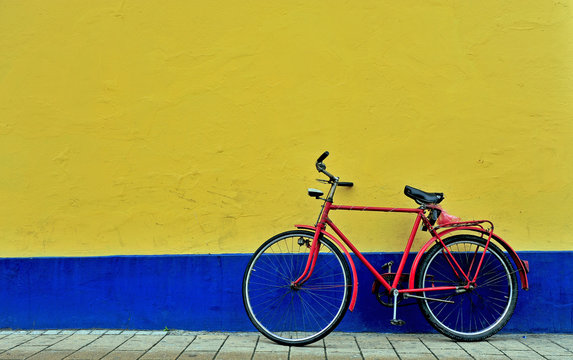 Bicycle parking in front of the yellow and blue wall