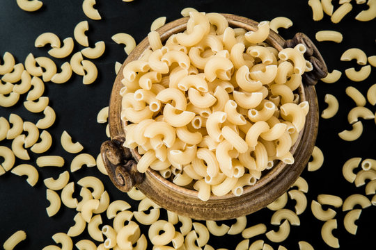 Macaroni pasta in the bowl on the macaroni background. Healthy eating and lifestyle.