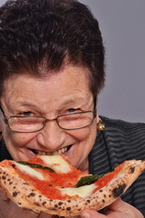 señora anciana comiendo pizza.