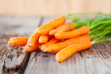 carrots with a tops of vegetable on a table, selective focus