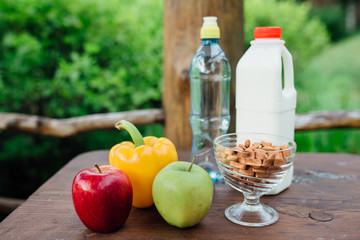 assorted fresh vegetables, peppers, apples, water and milk on wooden table. yoga, life concept, healthy eating  food.
