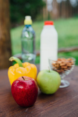 assorted fresh vegetables, peppers, apples, water and milk on wooden table. yoga, life concept, healthy eating  food.