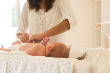 Obraz na płótnie Canvas Mother changing baby's diaper
