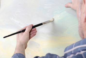 An artist painting landscape in studio. Selective focus