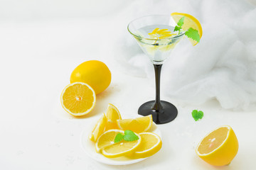 Tasty drink in the glass with lemons and mint. Special, white atmosphere. Freshness.
