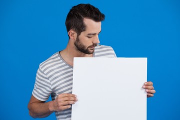 Handsome man holding a blank placard