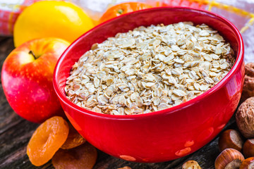 Oatmeal or oat flakes on dark wooden table
