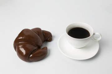 Coffee cup with a chocolate croissant