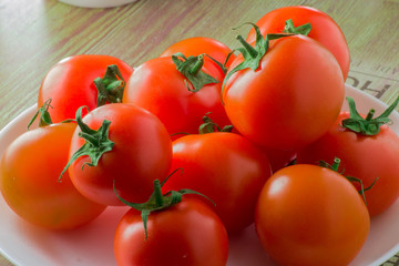 Group of tomatoes on a plate close-up on the table