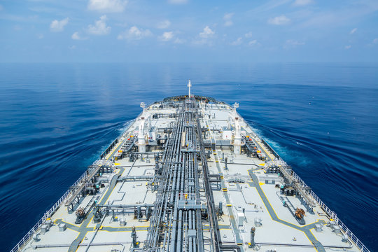 Grey oil tanker in calm blue ocean.