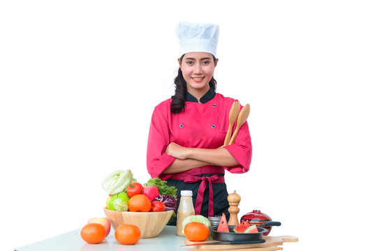 Young woman chef cooking vegetables salad in kitchen