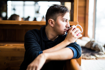Young man drink  tea in cafe in High Tatry mountains
