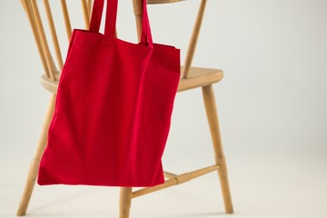 Red bag hanging on a wooden chair