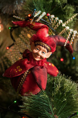 Decorated Christmas tree closeup. New Year baubles macro photo with bokeh. Red elf on Christmas card.	