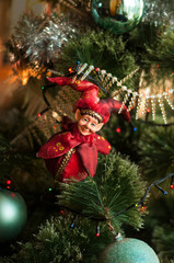 Decorated Christmas tree closeup. New Year baubles macro photo with bokeh. Red elf on Christmas card.	