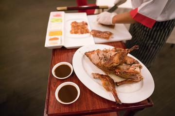 Perfectly cooked duck on a chopping board with a kitchen knife.
Preparation of Peking Roasted Duck. 
Peking Duck is a famous duck dish.
