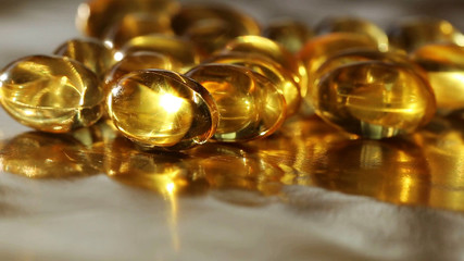 many oil capsules on a gold background. fish oil 1