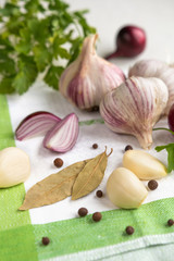 Fresh garlic, onion and spices on a light background closeup