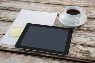 Fototapeta na wymiar Digital tablet with blank paper and cup of coffee