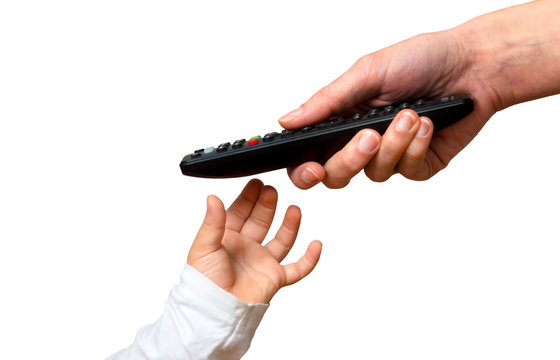 hand of child takes remote control of television from parent