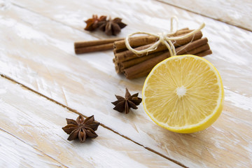 Half of lemon and spices on white wooden table