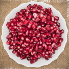 Ripe pomegranate seeds on a wooden table. Pomegranate fruit.