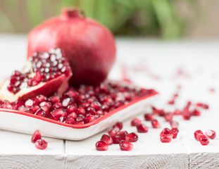 Ripe pomegranate seeds on a wooden table. Pomegranate fruit.